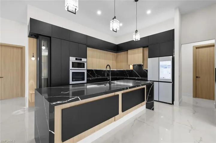 Kitchen featuring marble finish floor, modern cabinets, a sink, white appliances, and dark cabinets