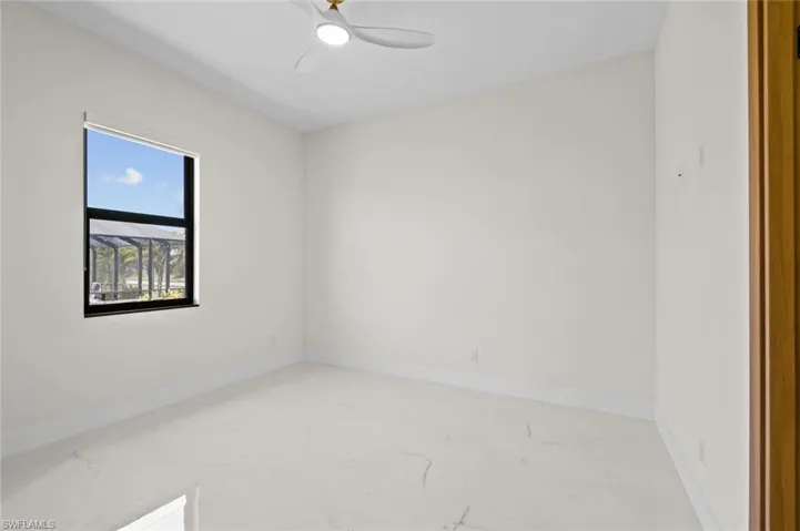 Unfurnished room featuring marble finish floor and baseboards