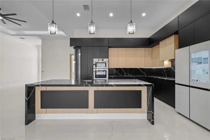 Kitchen with visible vents, modern cabinets, dark countertops, stainless steel double oven, and dark cabinets