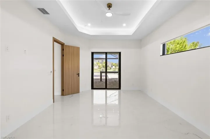 Empty room with baseboards, ceiling fan, recessed lighting, marble finish floor, and a raised ceiling