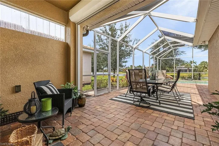 View of the patio showcasing a newer screened-in lanai, complete with a natural gas hookup for an outdoor kitchen or grill area.