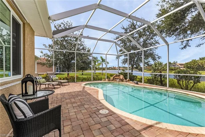 View of pool featuring newer screen enclosure and a patio area