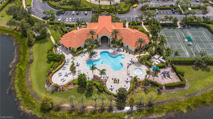 Aerial view of the community clubhouse, showcasing top-tier amenities, including tennis and pickleball courts, a fitness center, and a resort-style pool and spa.