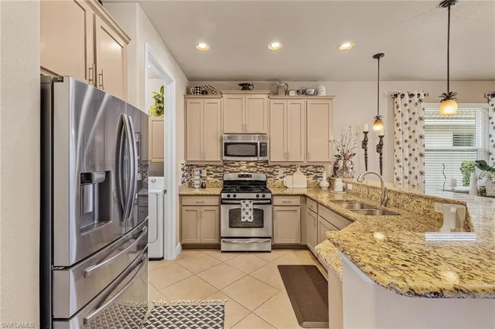 Kitchen featuring pendant lighting, sink, stainless steel appliances, and kitchen peninsula
