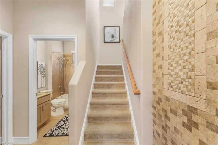 View of the guest bathroom and staircase leading to the upstairs loft, currently used as a fourth bedroom.