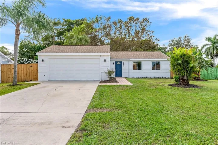 Single story home with a garage and a front lawn