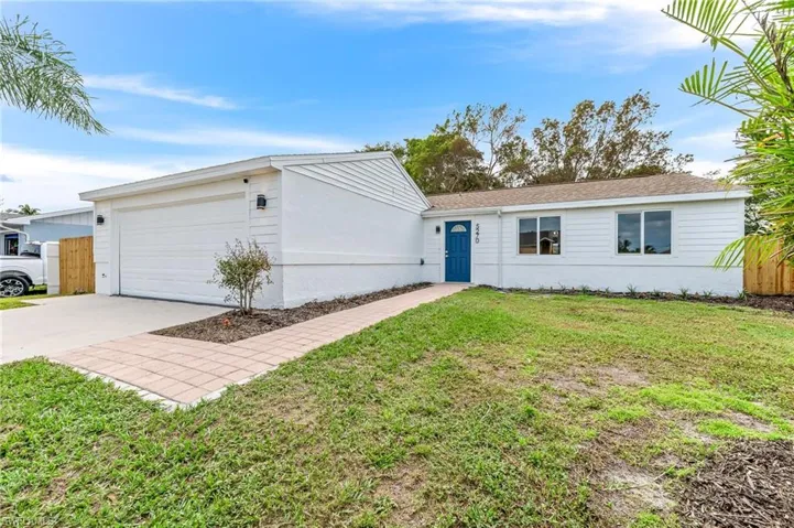 Ranch-style home with a garage and a front lawn