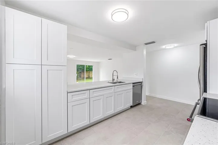 Kitchen with sink, electric stove, white cabinets, and dishwasher