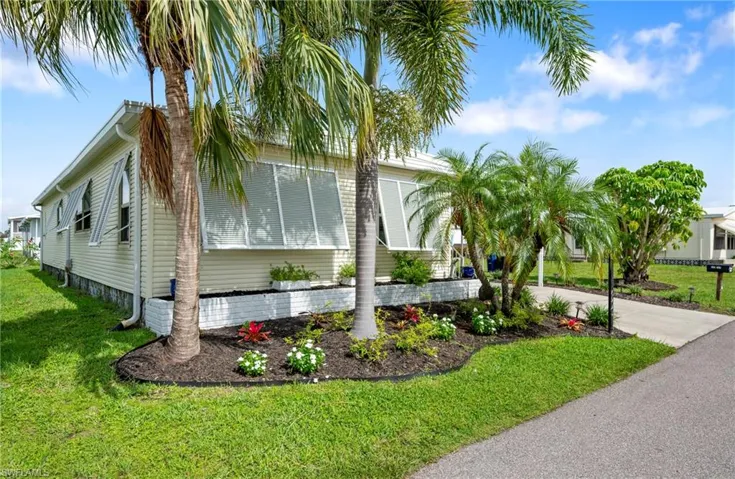 View of side of home with a yard and concrete driveway
