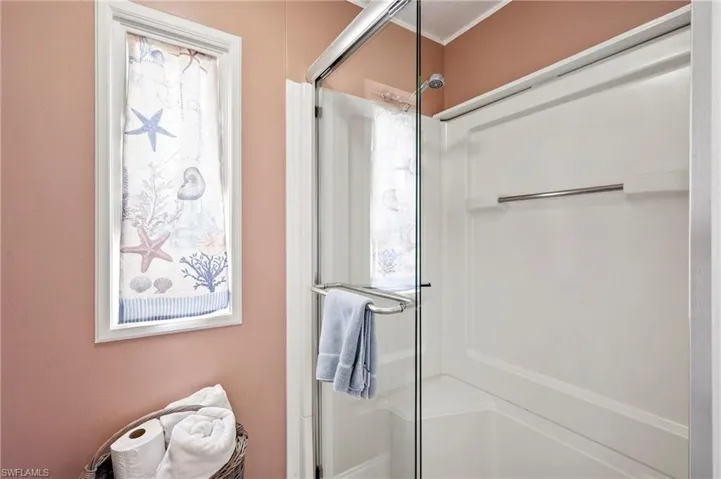 Bathroom featuring a shower stall and healthy amount of natural light