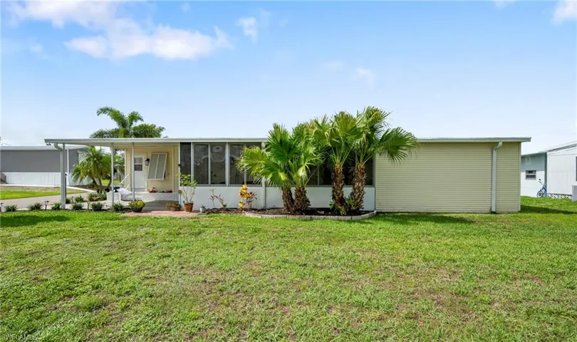 Manufactured / mobile home with a sunroom and a front lawn