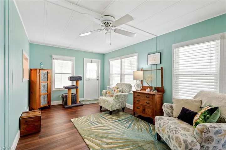 Living room featuring healthy amount of natural light, a ceiling fan, wood finished floors, and baseboards
