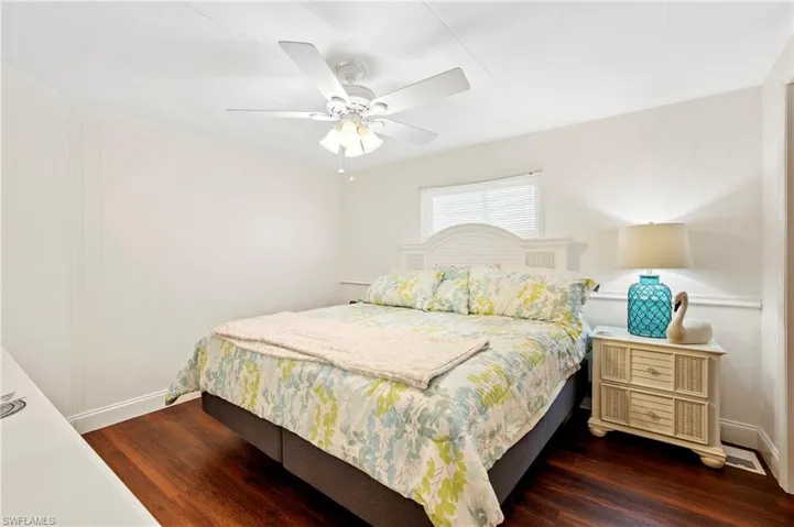 Bedroom featuring dark wood-type flooring, baseboards, and a ceiling fan