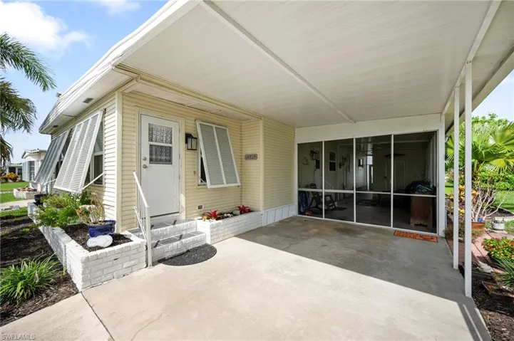 View of patio featuring a sunroom, an attached carport, and entry steps