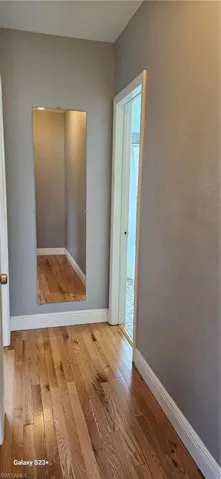 Empty room with hardwood / wood-style floors and baseboards