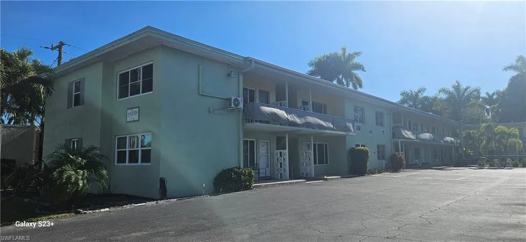 View of apartment building / complex with uncovered parking
