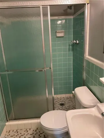Bathroom featuring a stall shower and tile walls