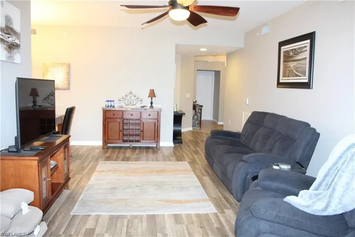 Living room with light wood-type flooring and ceiling fan