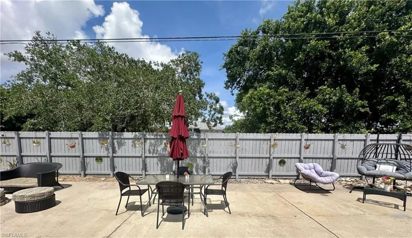 Expansive concrete patio area with a light grey privacy fence