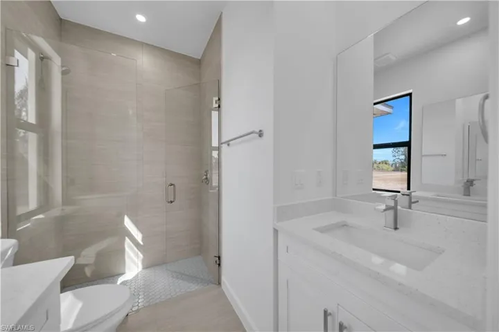 Full bathroom with vanity, a stall shower, and recessed lighting