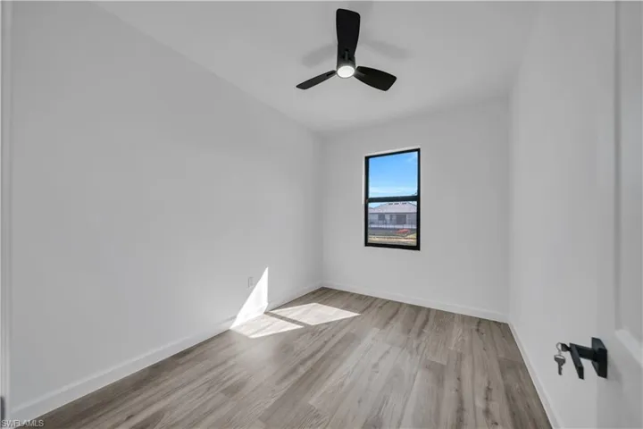 Empty room featuring light wood finished floors and a ceiling fan