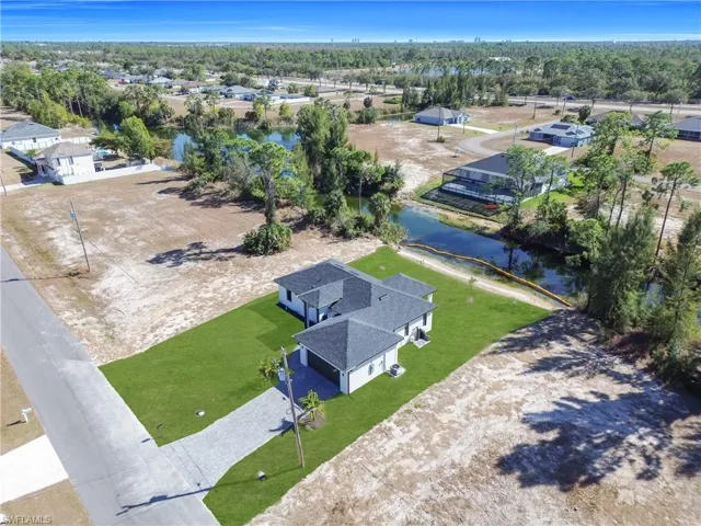 Drone / aerial view of a nearby body of water and a tree filled landscape