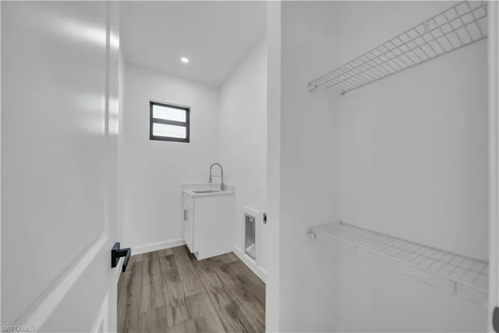 Laundry area with light wood-style floors and recessed lighting