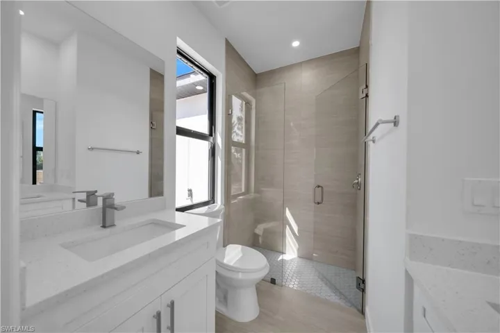 Bathroom featuring vanity, a shower stall, and healthy amount of natural light