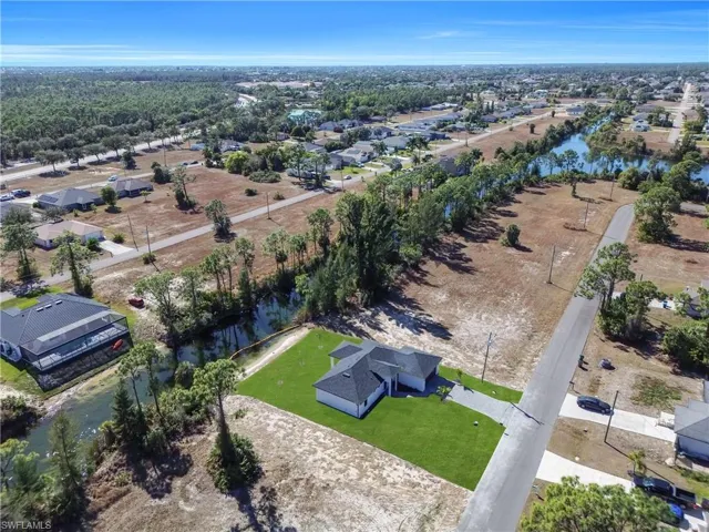 Aerial view of property and surrounding area with nearby suburban area and a large body of water