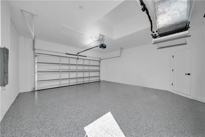 Garage featuring electric panel and a garage door opener