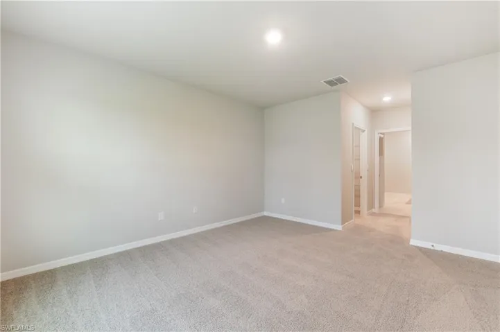 Unfurnished room with light colored carpet and recessed lighting