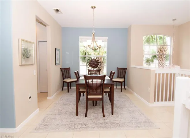 Spacious dining room featuring light tile floors, chandelier and a flexible floorplan for adding additional seating or storage.