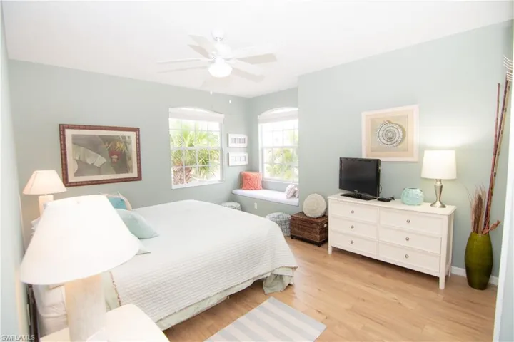 Bright and spacious second bedroom suite featuring LVP flooring, a charming window seat, a large closet for ample storage and a ceiling fan.