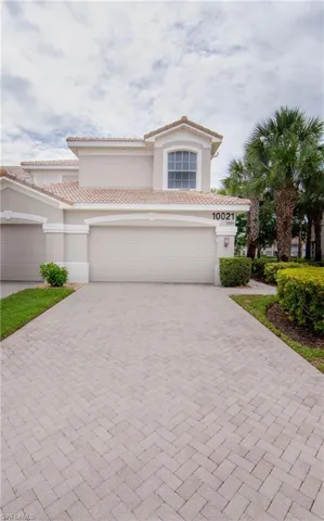 View of front of house featuring a 2-car garage and a beautiful paver driveway that will accommodate up to 4 vehicles.