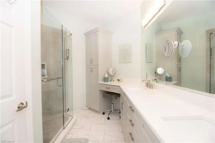 Spacious Master Bathroom features tile flooring, a walk-in custom tiled shower, a large vanity with Shaker style cabinets and dual sinks, quartz countertops, modern brushed chrome fixtures and a separate WC.