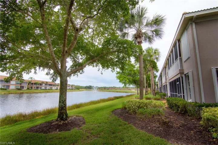 View of yard to the rear of the unit that features a water view of the pond and fountain along with a distant view of the golf course.
