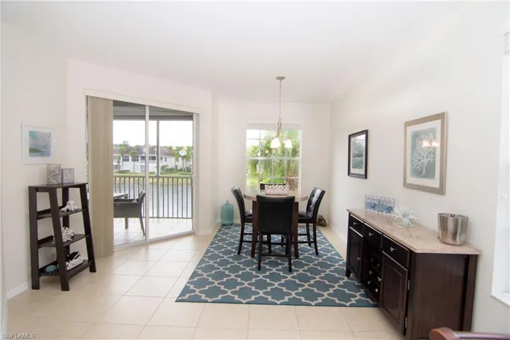 Dining area features a round pub height table with four chairs; a dry bar; dimmable lighting and attractive light tile flooring.  Slider leads  to the lanai from the Dining Area.