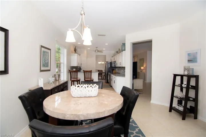 Spacious Dining Area overlooking the water view features a sliding glass door to the screened lanai for al fresco dining.