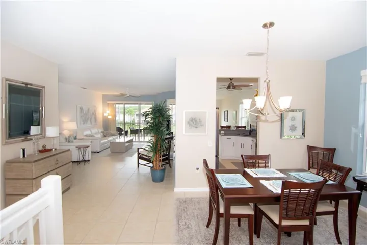 Spacious dining room featuring light tile floors, chandelier and a flexible floorplan for adding additional seating or storage.