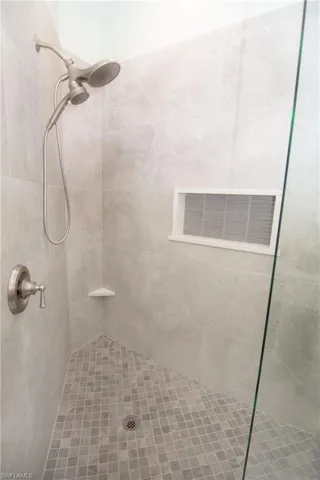 Custom tiled shower with frameless glass door.