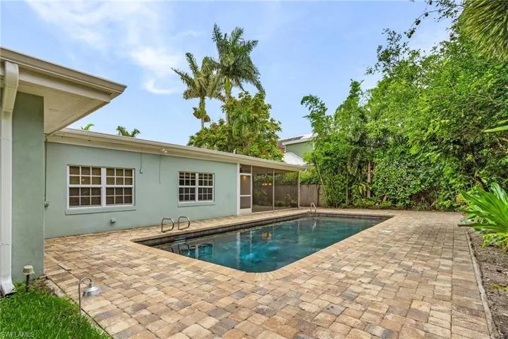 View of swimming pool with pavers, fully denced back yard
