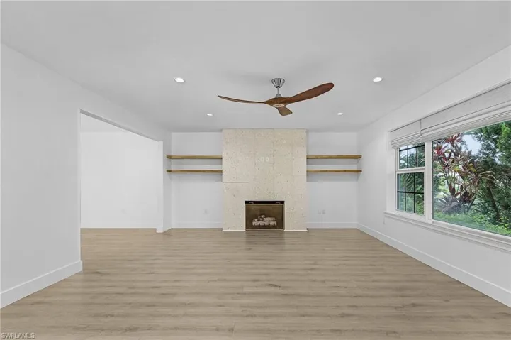 Living room with ceiling fan, recessed lighting, light wood-style flooring, and a fireplace