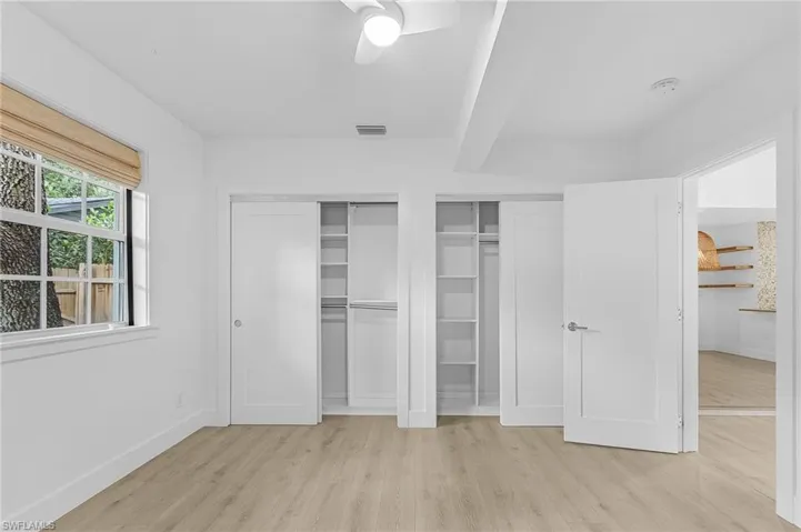 Bedroom featuring light wood-style floors, two closets, and ceiling fan