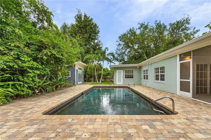 Outdoor pool with a patio area and an outdoor structure