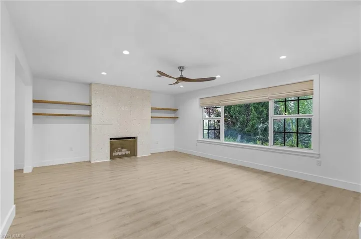 Living room featuring ceiling fan, light wood-style flooring, recessed lighting, and a large fireplace