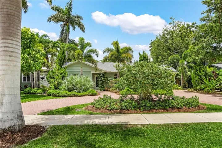 View of front of home with decorative driveway and a front yard