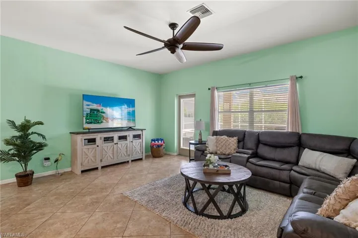 Living room with light tile patterned floors and ceiling fan