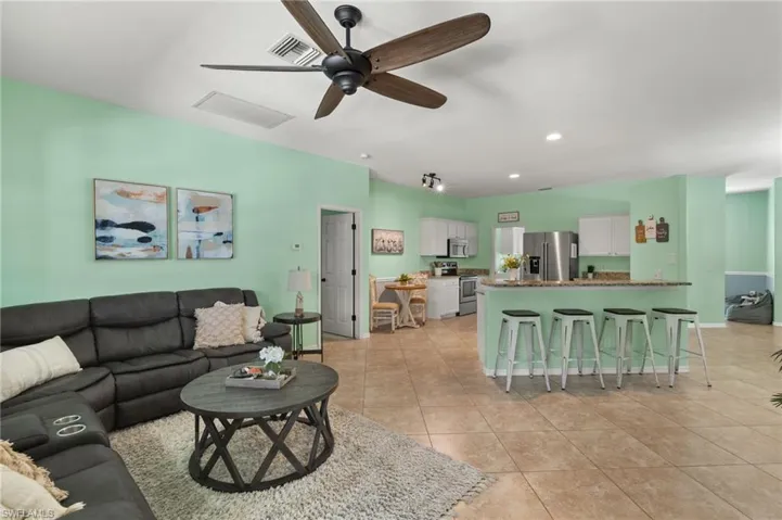 Living room featuring light tile patterned floors and ceiling fan