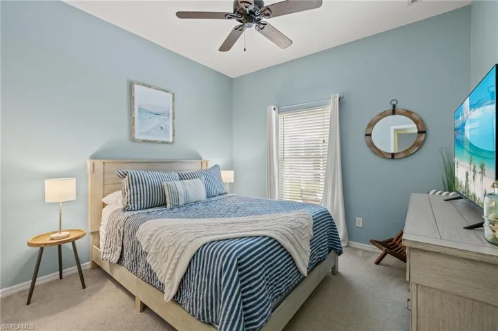 Carpeted bedroom featuring ceiling fan