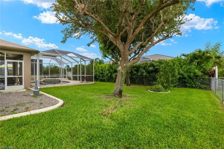 View of yard with glass enclosure, a swimming pool, and a patio area